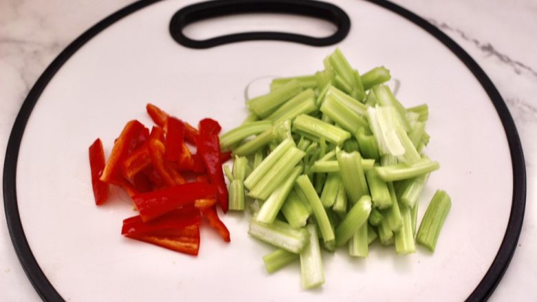 皮蛋肠辣炒芹菜,芹菜洗净后用刀切成段，红椒去籽后用刀切成条。