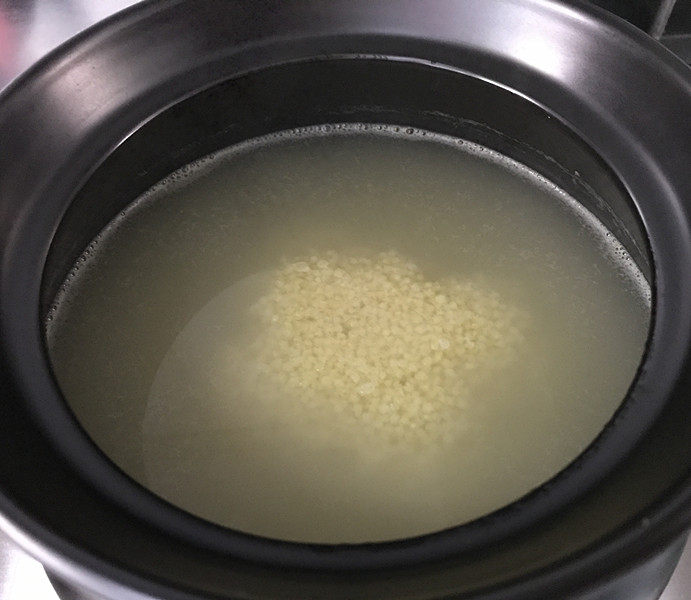 小米炖海参,10分钟后小米已明显涨开了，用勺子把小米搅拌一下以防粘锅，开大火，煮沸后同样把火关掉