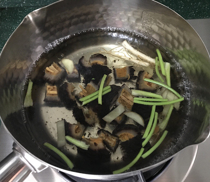小米炖海参,锅中加入生姜、香菜梗、香菜头、食用油和适量清水，大火煮沸后放入红极参，焯烫几十秒捞出备用