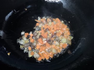 腊肉蛋黄烧麦,倒入胡萝卜翻炒。