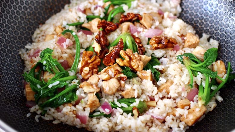 鸡丁核桃菠菜炒饭,大火翻炒均匀后，上面撒上炸香的核桃即可关火。