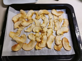 烤苹果片,取出翻动 随着加热 苹果片慢慢脱水 缩小 将两盘合并成一盘