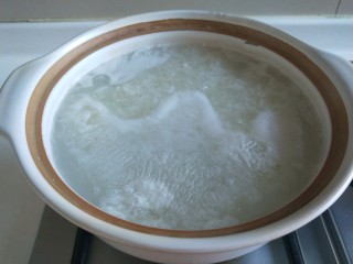 鲜虾砂锅粥,加入开水，倒入剩米饭熬制。