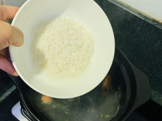 鲜虾砂锅粥,把大米倒入沸水里；