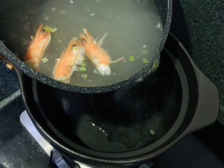 鲜虾砂锅粥,把煮沸的水倒入砂锅里；