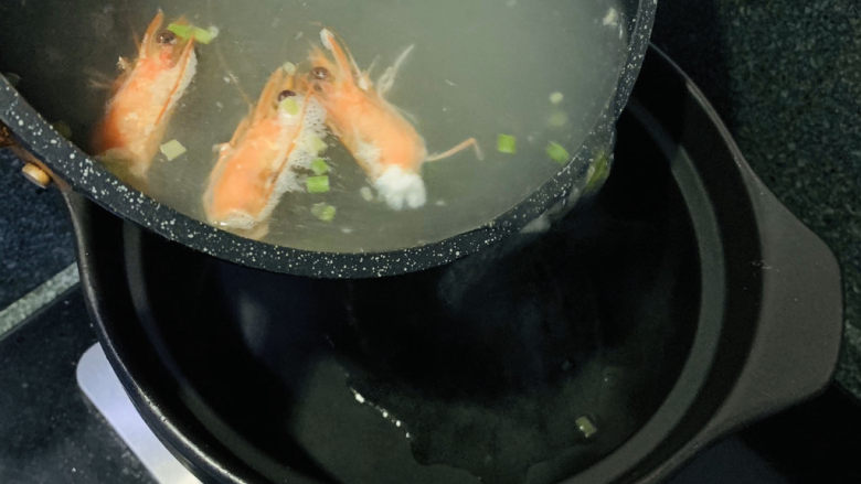 鲜虾砂锅粥,把煮沸的水倒入砂锅里；
