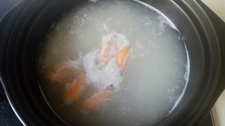 鲜虾砂锅粥,虾头放入炒锅中加入适量油炒出虾油，加入适量清水煮开，倒入砂锅中