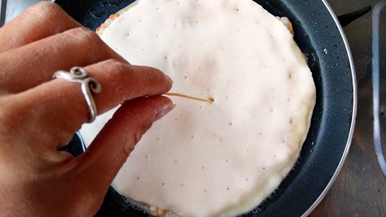 鲜虾饼,放入饼坯，并用牙签在虾饼上均匀的戳出气孔，这样煎的时候更容易均匀受热，饼不会鼓大泡。