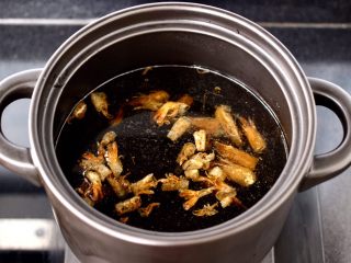 鲜虾砂锅粥,砂锅里倒入适量的清水，放入榨好的虾壳和虾头。