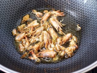 鲜虾砂锅粥,锅烧热后倒入花生油烧热，把虾壳和虾头放入锅中慢慢炸酥。