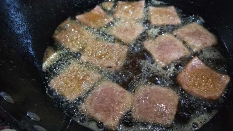 干锅藕片,倒入午餐肉过油捞出来。