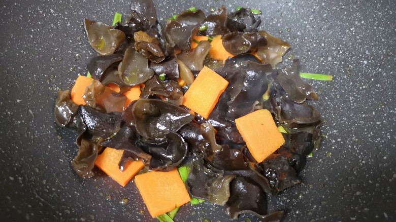 黄瓜木耳炒鸡蛋,下入黑木耳和胡萝卜翻炒均匀。
