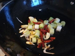 宫爆鸡丁,锅中倒入适量油炒香葱姜蒜，干辣椒，倒入葱段。