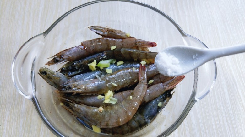 椒盐基围虾,加入切好的葱姜，再加入盐，抓拌均匀。
