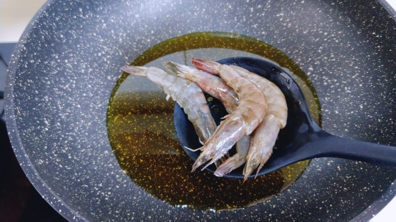椒盐基围虾,锅中倒入菜籽油，油温6.7成热时，将腌制好的虾轻轻拍上薄薄一层淀粉，下入油锅。