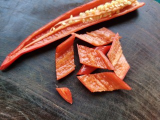 黄瓜木耳炒肉,红辣椒从中间切开，去掉辣椒籽切成片。
