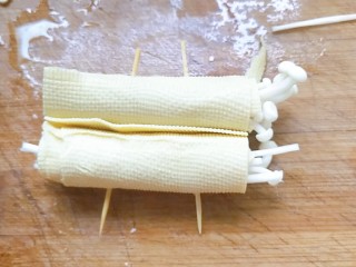 烤箱版豆皮金针菇,两个豆皮卷串在两个牙签上