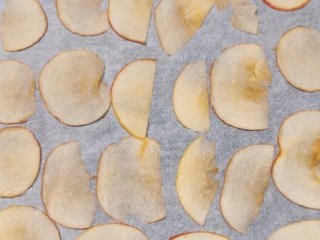 烤苹果片,将苹果切成薄片，烤盘中垫上烘培油纸，摆上苹果片；