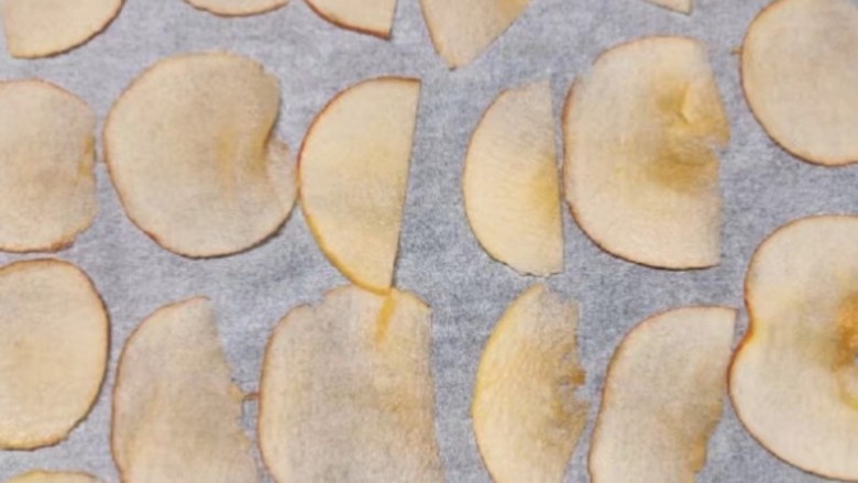 烤苹果片,将苹果切成薄片，烤盘中垫上烘培油纸，摆上苹果片；