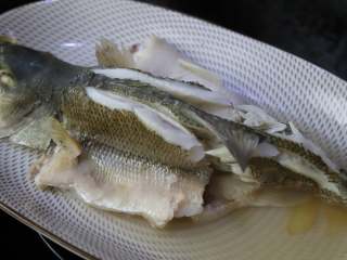 清香蒸鲈鱼,鱼蒸好以后盘子里会有不少蒸鱼的水，把这个水倒掉。
