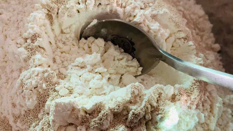 红枣红糖馒头,用勺子将酵母粉和面粉搅拌均匀，这会不要用手搅拌，干酵母粉很容易吸附在手上；