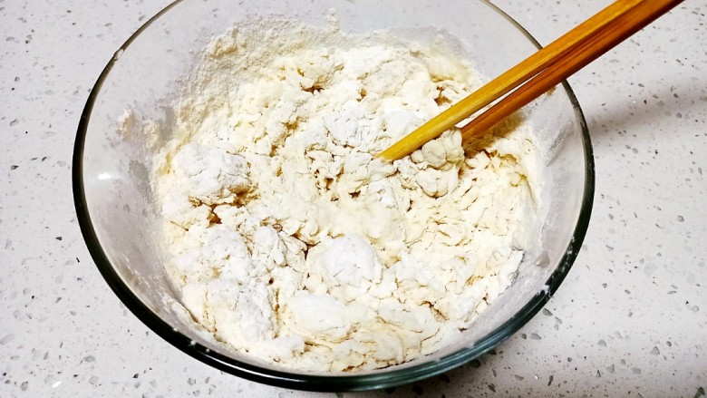 小葱五香手抓饼,面粉称好加入盐，从中间一分为二，一半加入开水，一半加入凉水，搅拌成絮状。