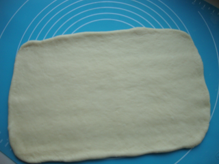 肉松面包卷,擀成烤盘大小的面片，要均匀一些，最好直接在下面垫一张烤盘大小的油纸或者油布，比较好操作。