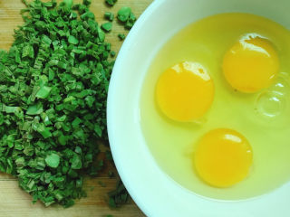 香椿炒鸡蛋,鸡蛋打入碗中。