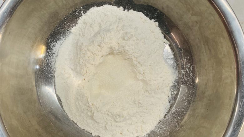 法棍面包🥖,筛入面粉中间挖坑放入白糖。