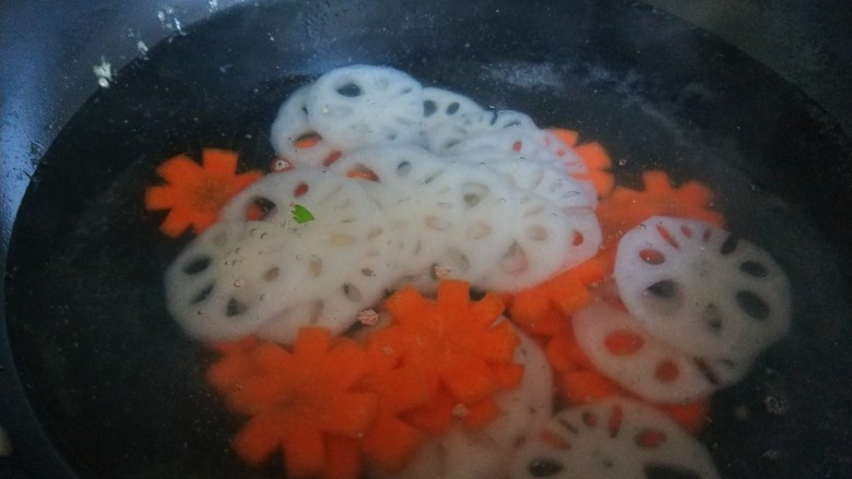 醋溜藕片,锅中倒入适量水烧开，倒入藕片，胡萝卜片焯一下水。