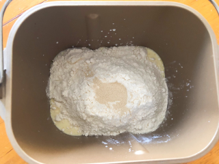椰丝小面包,将黄油以上全部材料放入面包机中，揉面10分钟。