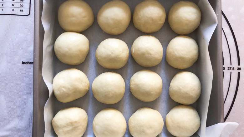 椰丝小面包,拿出排气，分成均等的16等份，揉圆放入烤盘。