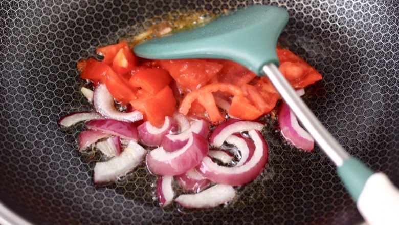香煎三文鱼&炒意面,锅烧热后倒入剩下的10克橄榄油，先炒香洋葱后加入番茄。