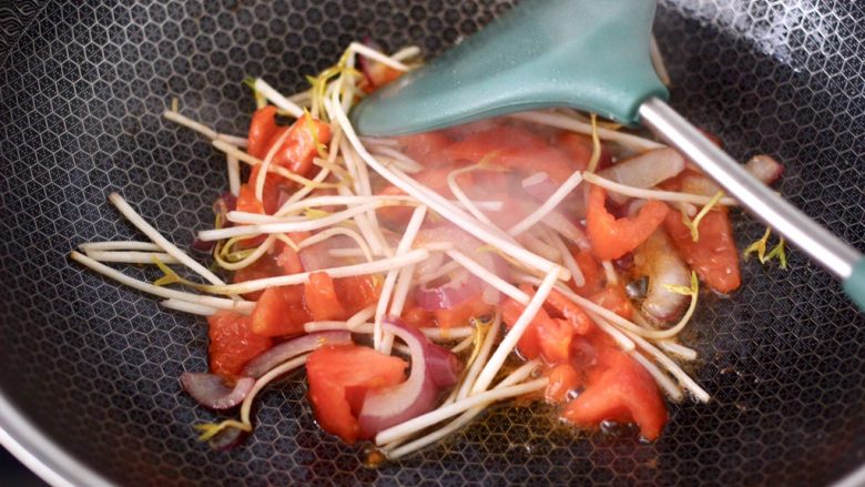 香煎三文鱼&炒意面,大火快速翻炒至番茄变软，加入绿豆芽继续翻炒均匀。