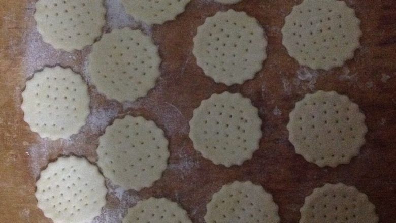 咸味小饼干,面板上把面团擀开，用模具压出饼干花纹，叉子戳洞