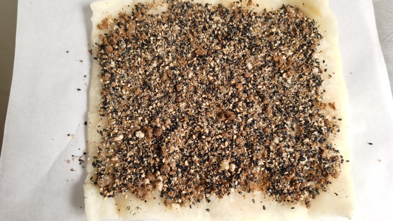 红糖麻糍,煎好后的糯米片取出来，上面铺上混合好的红糖芝麻。