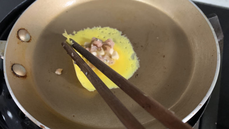 香菇瘦肉蛋饺（宝宝辅食）,用筷子从蛋皮的一边夹起折过来