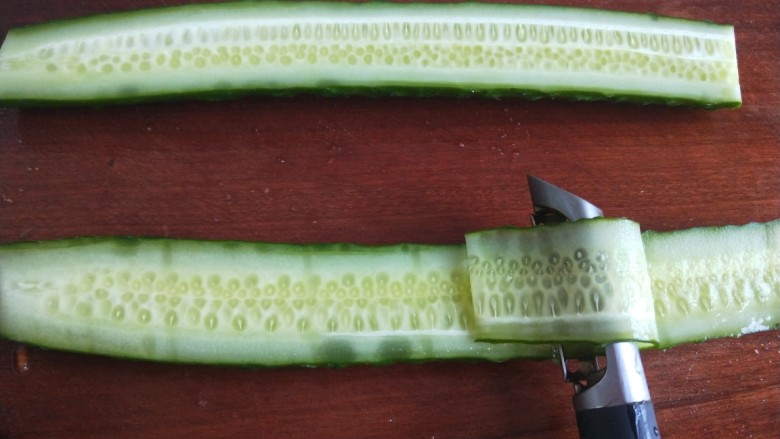 凉拌黄瓜卷,用刮皮刀来刮成长片。
