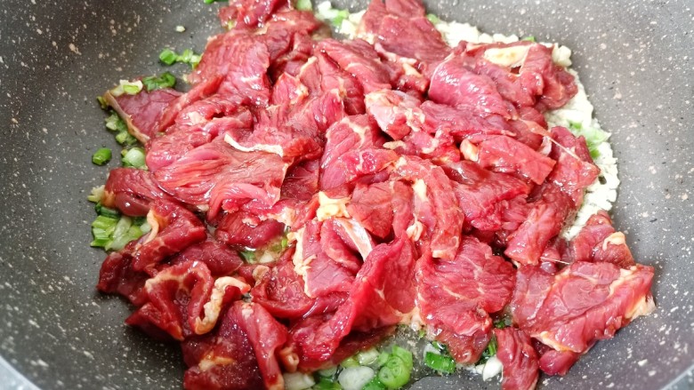 爆炒牛肉丝,把腌制好的牛肉放入锅里，用铲快速将牛肉炒散。