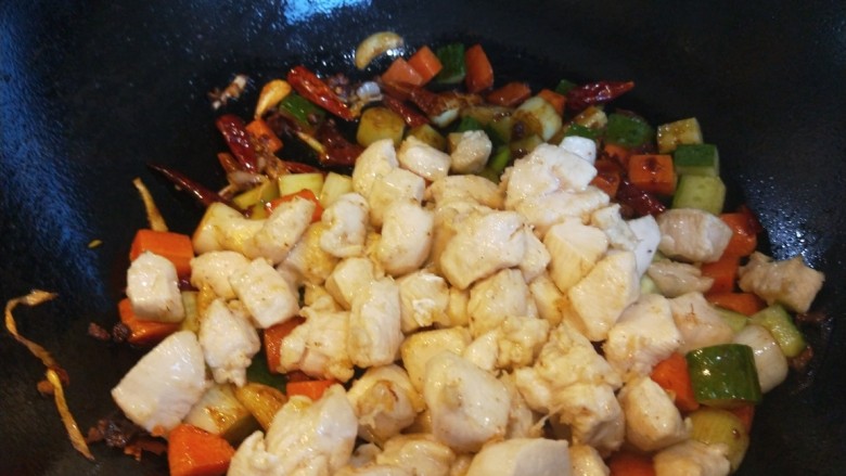 麻辣干锅鸡,辣椒块炒均匀，倒入鸡丁。