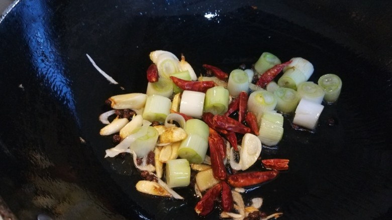 麻辣干锅鸡,锅中倒入五十克油烧热，放入花椒，葱姜蒜，干辣椒炒均匀。