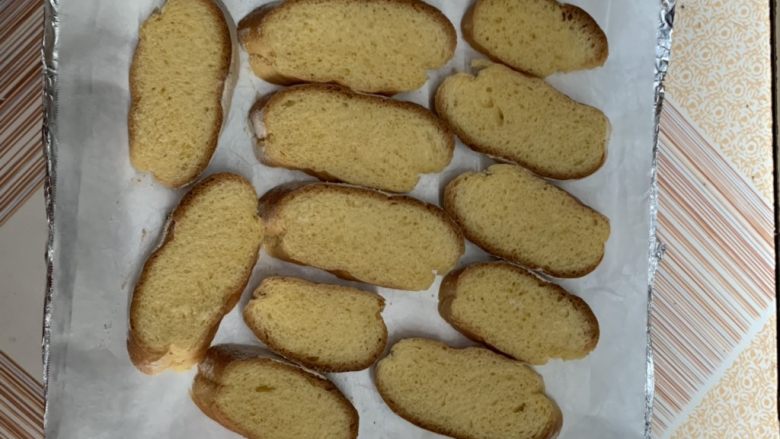 甜脆面包片,铺油纸上烤盘摆上面包片。