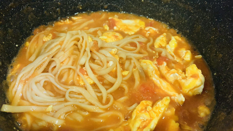 鸡蛋西红柿打卤面,用筷子翻拌面条，面条和汤料融合一起；