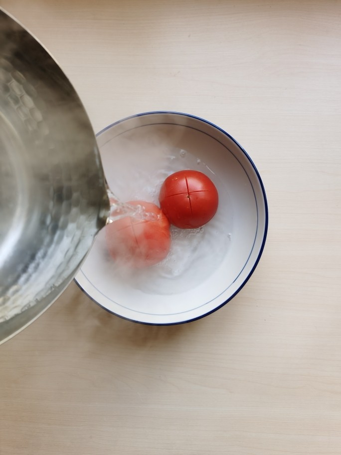 鸡蛋西红柿烩杠子头,<a style='color:red;display:inline-block;' href='/shicai/ 3551'>西红柿</a>顶部切十字花刀，用开水烫一下。