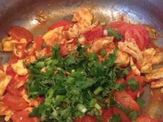 西红柿炒鸡蛋,撒入葱花碎香菜来提味装饰