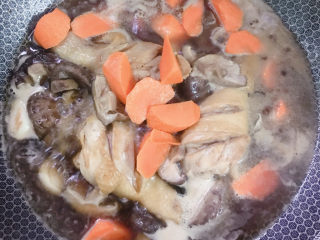 鸡腿炖香菇,将胡萝卜放入锅中，加盐