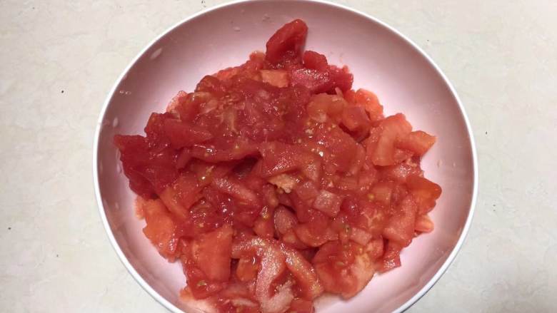 鸡蛋西红柿打卤面,西红柿顶部划十字花刀，泡入热水中去掉皮，改刀切成小粒