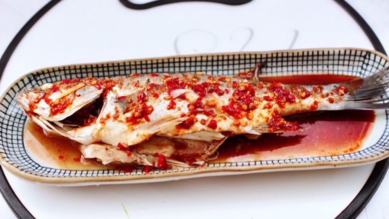 香辣酱蒸鲈鱼,然后把鲈鱼换到摆盘里，再把调料汁均匀的浇到鲈鱼身上。