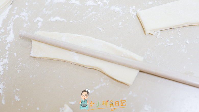  36个月以上辅食自制油条,用筷子沾水把两个长方形叠在一起，再用筷子压一下
