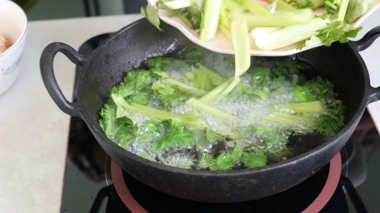 麻辣干锅鸡,油热后放入芹菜，烫熟后捞出备用
